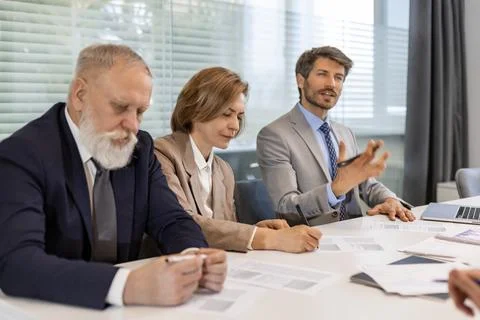 Group of young modern people using modern technologies while working in the.. Stock Photos