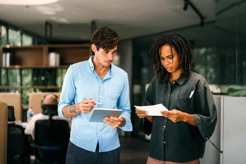 Group of young multi-ethnic startup business team collaborating on project in Stock Photos