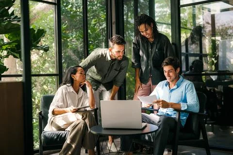 Group of young multi-ethnic startup business team collaborating on project in Stock Photos