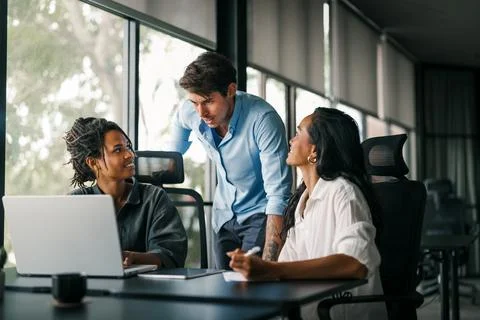 Group of young multi-ethnic startup business team collaborating on project in Stock Photos