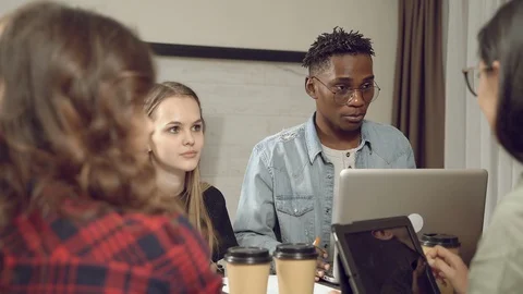 Group of young multiethnic people discussing a joint project at a meeting Stock Footage 129746563