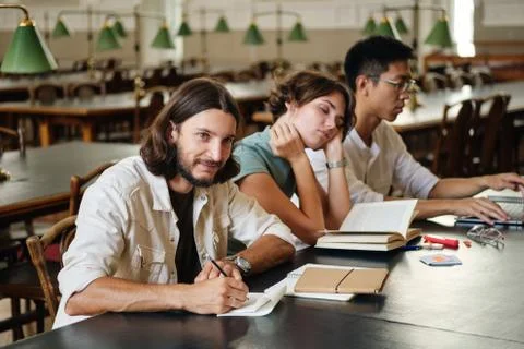 Group of young multinational students studying together in library of university Foto stock