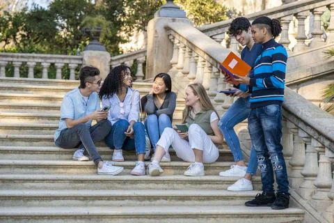 Group of young multiracial students talking on some stairs Stock Photos
