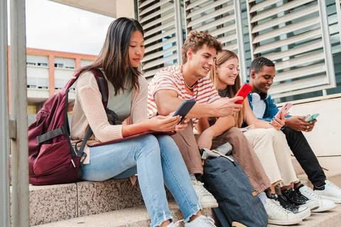 A group of young multiracial students using a cellphone to check their exam Stock Photos