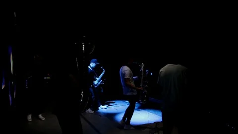 A group of young musicians playing on stage on instruments in black and white Stock Footage 92818909