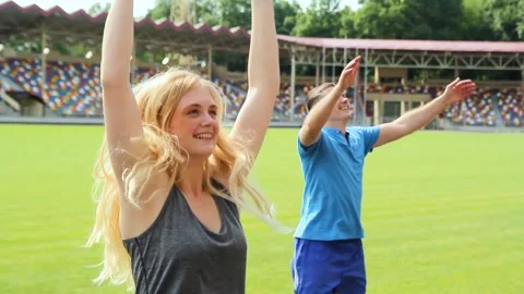 A group of young people are doing fitness at the stadium Stock Footage 130801830