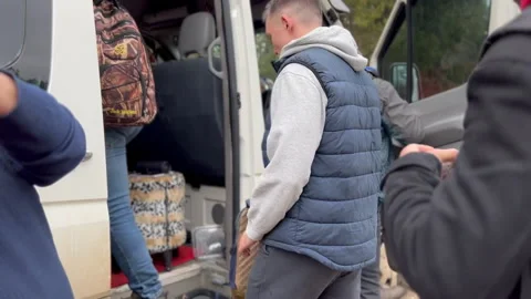 Group of young people with backpacks getting in white minivan day time Stock Footage 235662889