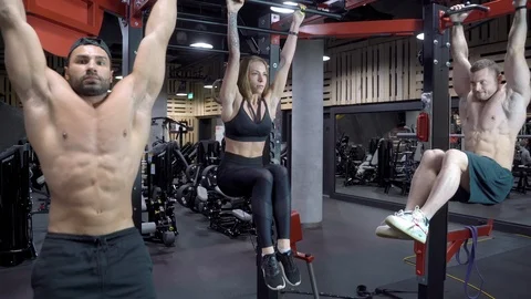 Group of young people doing abdominal muscle exercises using a horizontal bar Stock Footage 108904378