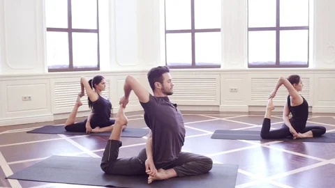 Group of young people doing yoga in the class with windows Stock Footage 76182275