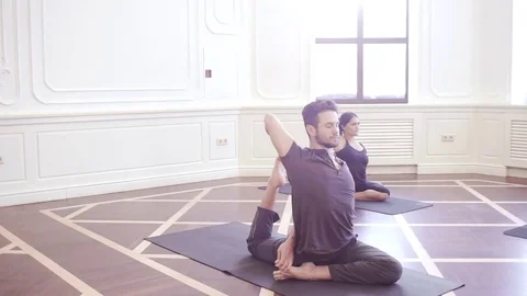 Group of young people doing yoga in the class with windows Stock Footage 76182307