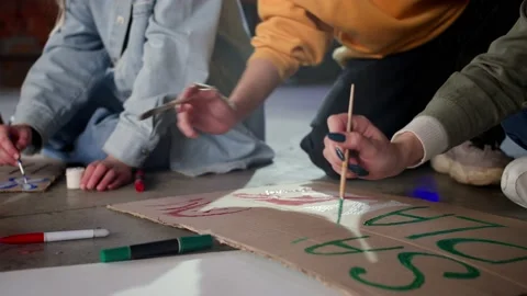 A group of young people draw posters and protest against environmental pollution Stock Footage 233220271