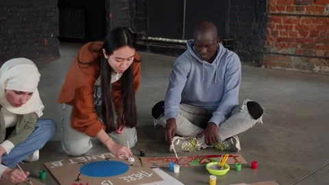 A group of young people draw posters and protest against environmental pollution Stock Footage 233220310