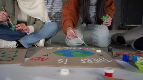 A group of young people draw posters and protest against environmental pollution Stock Footage 233220396