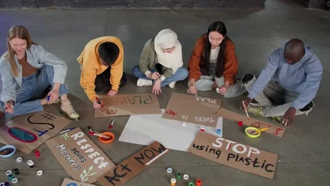 A group of young people draw posters and protest against environmental pollution Stock Footage 233220683