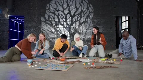 A group of young people draw posters and protest against environmental pollution Stock Footage 233220706