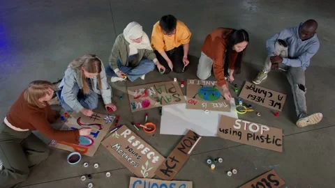 A group of young people draw posters and protest against environmental pollution Stock Footage 233220808