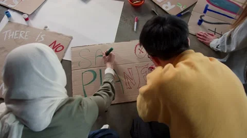 A group of young people draw posters and protest against environmental pollution Stock Footage 233220918