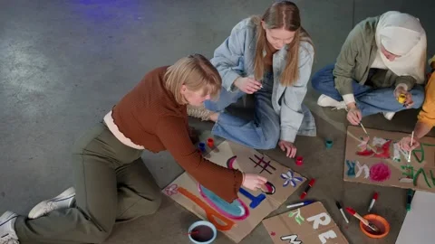 A group of young people draw posters and protest against environmental pollution Stock Footage 233221054