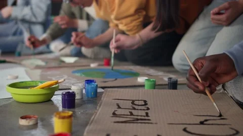 A group of young people draw posters and protest against environmental pollution Stock Footage 233221069