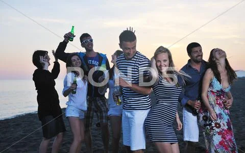 Group Of Young People Enjoy Summer Party At The Beach