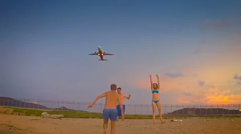 Group of young people having fun on the background of airplane taking off Stock-Footage 63979259