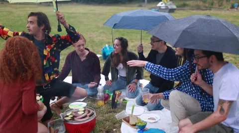 Group of young people having fun during picnic in spite of the rain Stock Footage 66025496