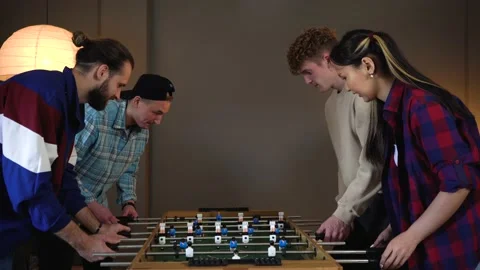Group of young people having fun playing in table soccer at Home Stock Footage 150290443
