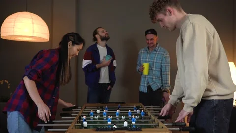 Group of young people having fun playing in kicker at Home Party. Drinking beer Stock Footage 150290482