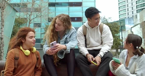 Group of young people laughing while looking at their smart phones 库存影片 243439266