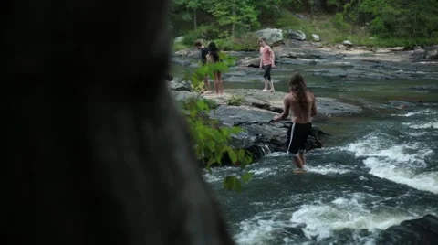 Group of young people playing in a river Stock Footage 44672872