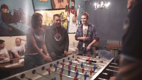 Group of young people playing table soccer in the bar Stock Footage 71065936
