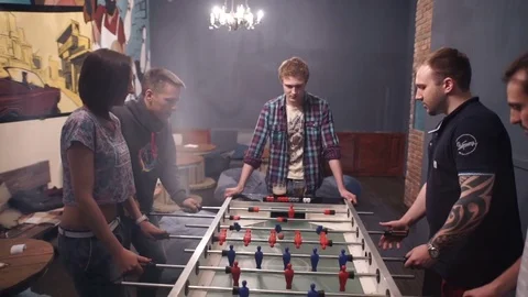 Group of young people playing table soccer in the bar Stock Footage 71066387