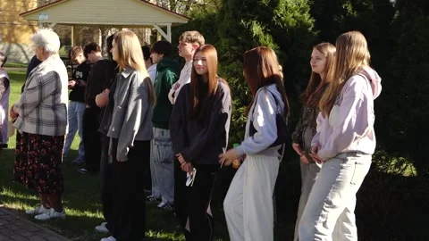 Group of young people posing outdoors beneath European Union flag bunting Stock Footage 335172522