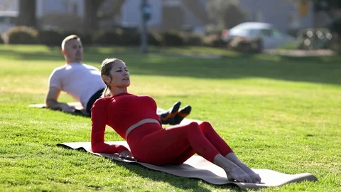 Group of young people practicing yoga on the seaside during the day. Green Grass Stock-Footage 110852277