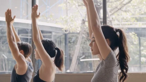 Group of young people practicing yoga In the prayer position and raised hands Stock Footage 124179974