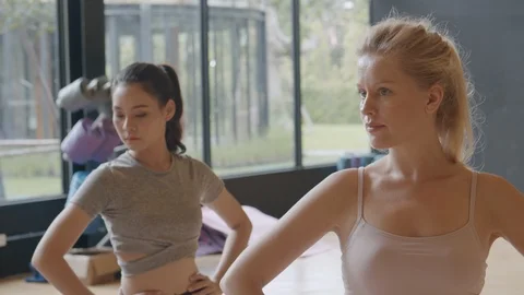 Group of young people practicing yoga warrior posing in the gym or studio Stock Footage 124814632