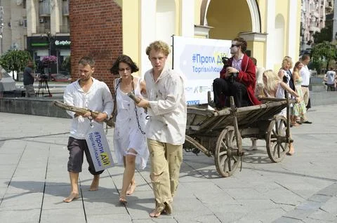 Group of young people pulling an old cart on a street. Street action protes.. Stock Photos