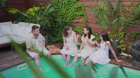 A group of young people relax by the pool. Toast, fun and alcohol at a summer Stock Footage 162465258