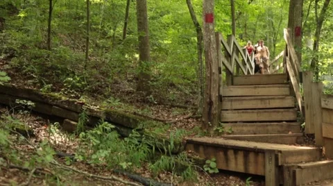 Group of young people running down stairs in the forest in slow motion Stock Footage 44674610