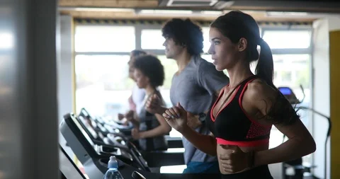 Group of young people running on treadmills in sport gym Stock Footage