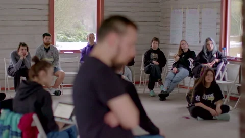 Group of young people sit in circle on chairs during meeting Twelve-step program Видео 238483492