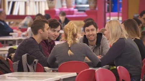A group of young people sitting at a table of a fast food restaurant.communicate Stock Footage 113803058