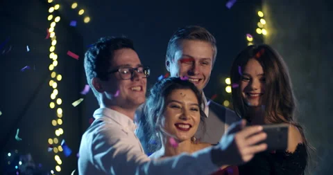 A group of young people smiling and throwing confetti, taking selfies for the Vidéo 161047378
