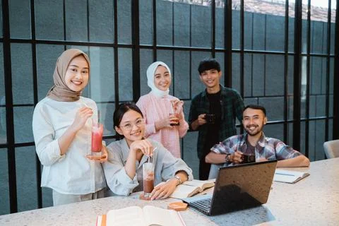 Group of young people smiling while enjoying gathering in cafe Stock Photos