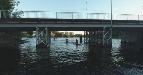 A group of young people surfing down the river on the boards with the paddles. A Stock Footage 81793951