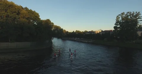A group of young people surfing down the river on the boards with the paddles. A Video stock 81793991