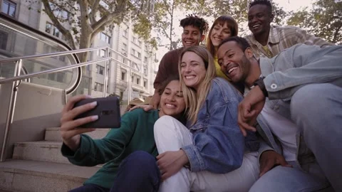Group of young people taking a selfie with their phones sitting on the stairs Stock Footage 231913489