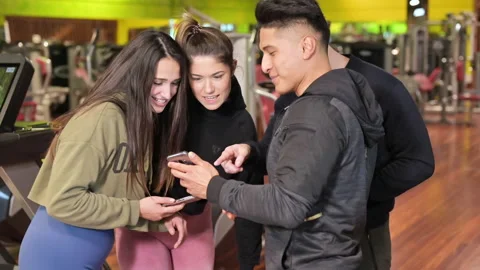 Group of young people using and looking at mobile phone together Stock Footage 146289298