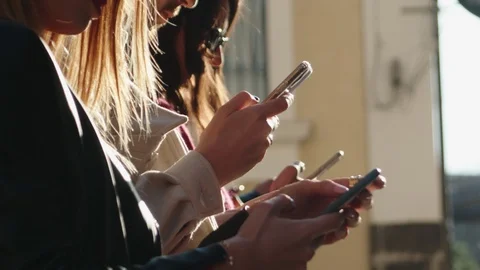 Group of young people using mobile phone in backlight Stock Footage 125448221