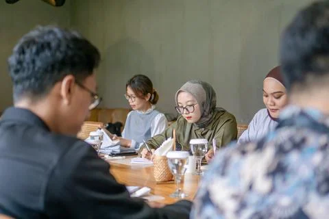 A group of young professionals collaborating during a business meeting in a.. Stock Photos